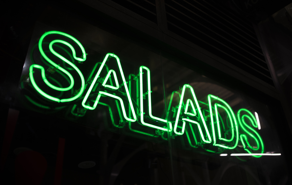 letrero luminoso verde que lee la palabra salads